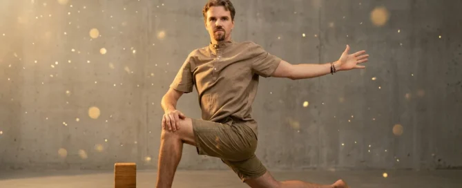 Professor de Yoga, Gilberto Schulz, fazendo anjaneyasana enquanto instrumento da terapia somática e interocepção para regulação do sistema nervoso